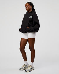 Woman wearing Static Grit Unisex Boxy Hoodie - Black-Alloy | Model:Ellie | Size:XS