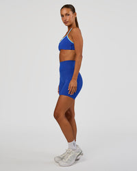 Woman wearing Tempo Sports Bra - Electric Indigo-Baltic Sea | Model:Brylee | Size:XS