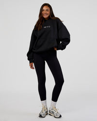 Woman wearing Trust The Process Unisex Oversized Hoodie - Black-White | Model:Kirstyn | Size:XS