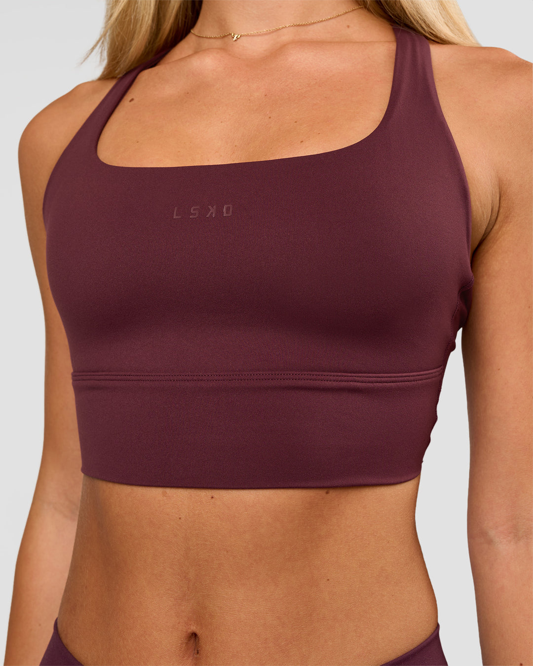 Woman wearing Twist Long Line Sports Bra in Cherry Lacquer | Model:Issy | Size:XS