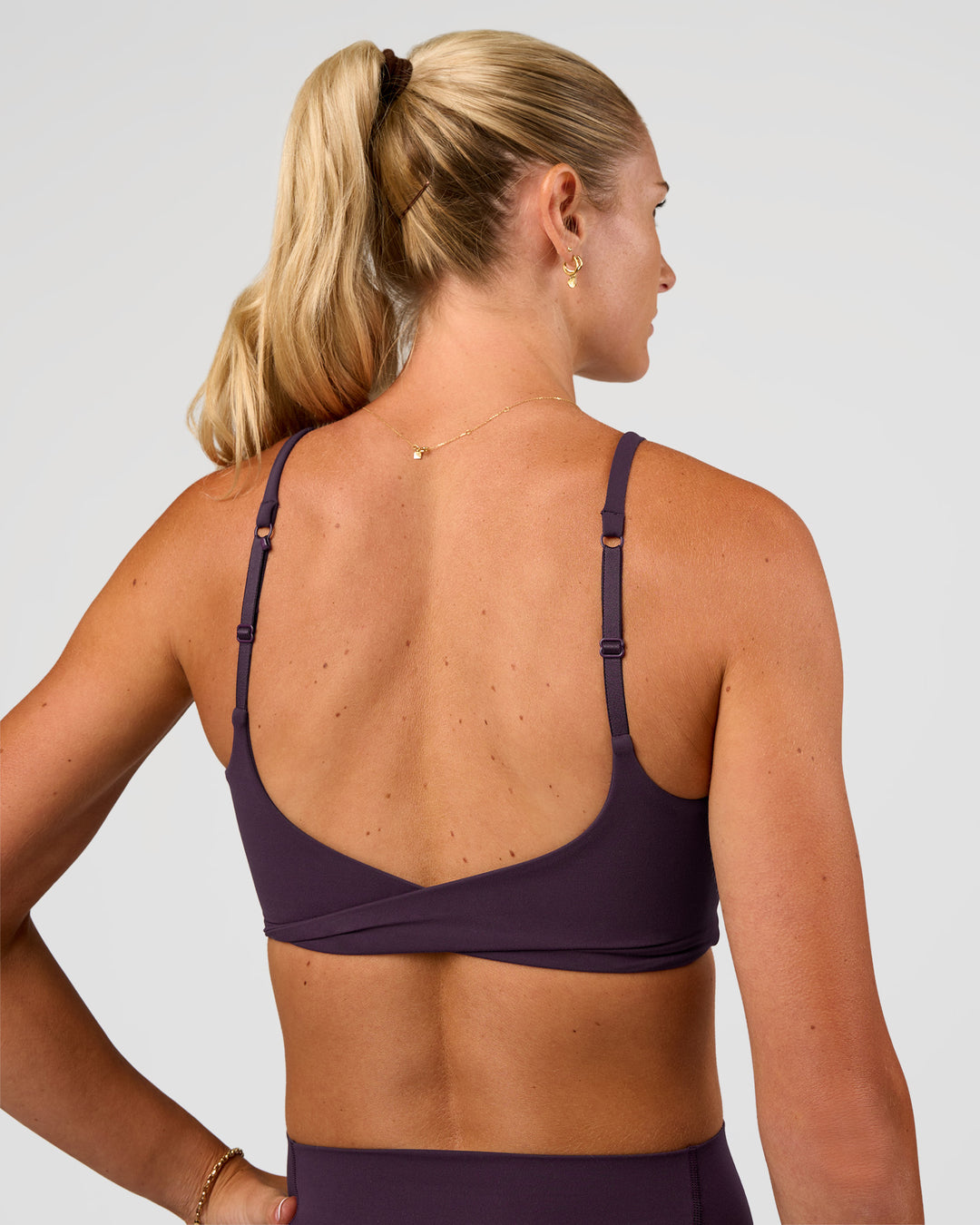 Woman wearing Twist Sports Bra - Midnight Plum | Model:Emelia | Size:XS