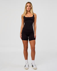 Woman wearing Twist Square Neck Shelf Bra Tank in Black | Model:Issy | Size:XS