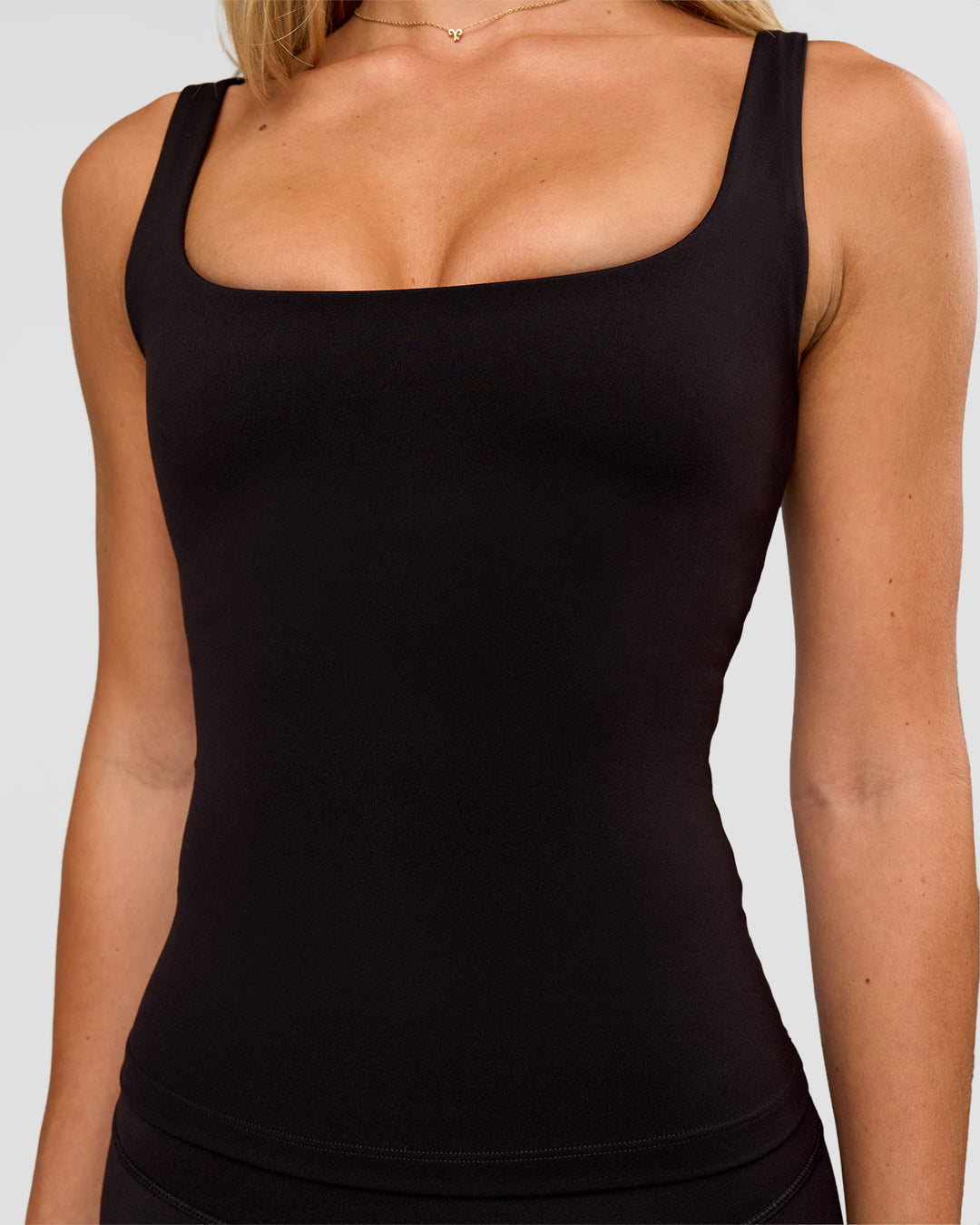 Woman wearing Twist Square Neck Shelf Bra Tank in Black | Model:Issy | Size:XS