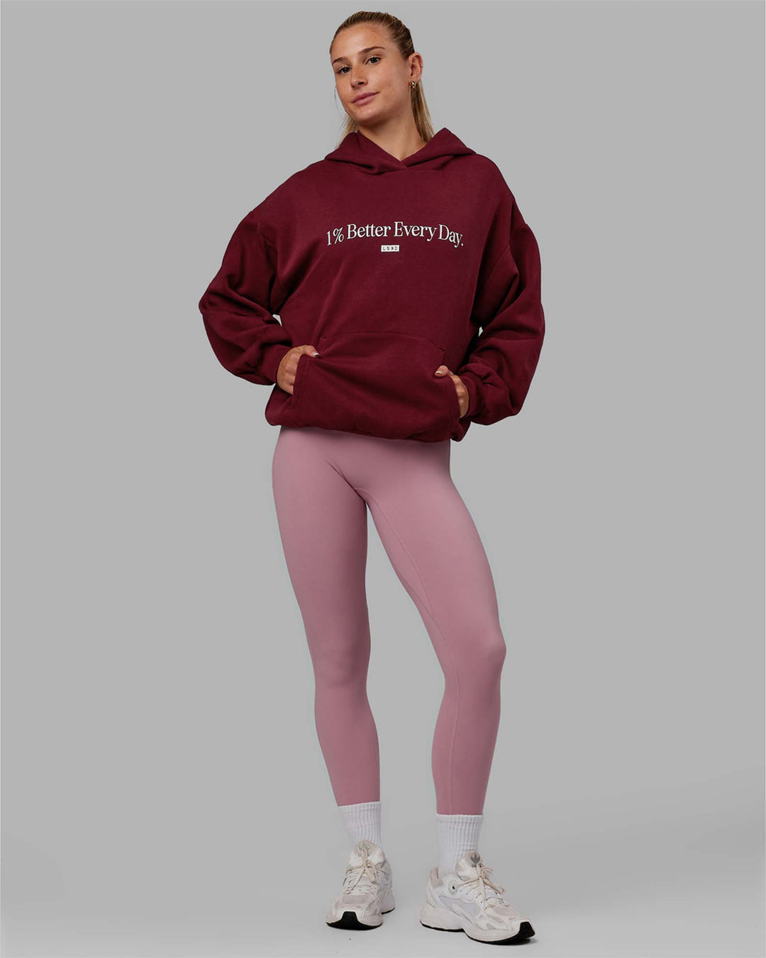 Woman wearing Unisex 1% Better Hoodie Oversize - Cranberry-White