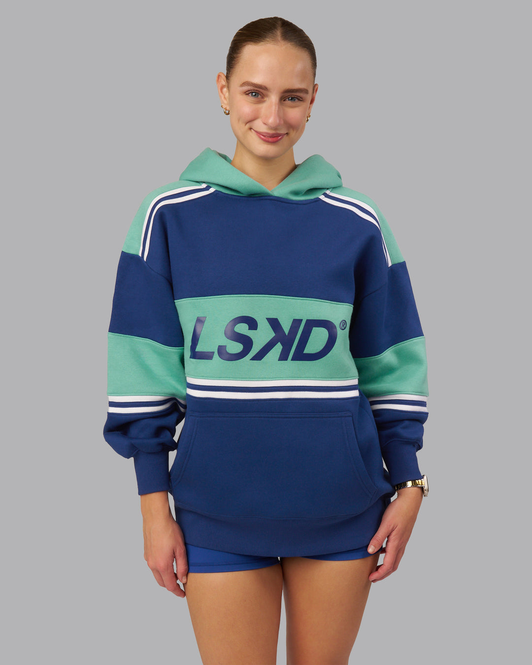 Woman wearing A-Team Oversized Hoodie - Midnight Blue-Agate Green | Model:Lillie| Size:XS