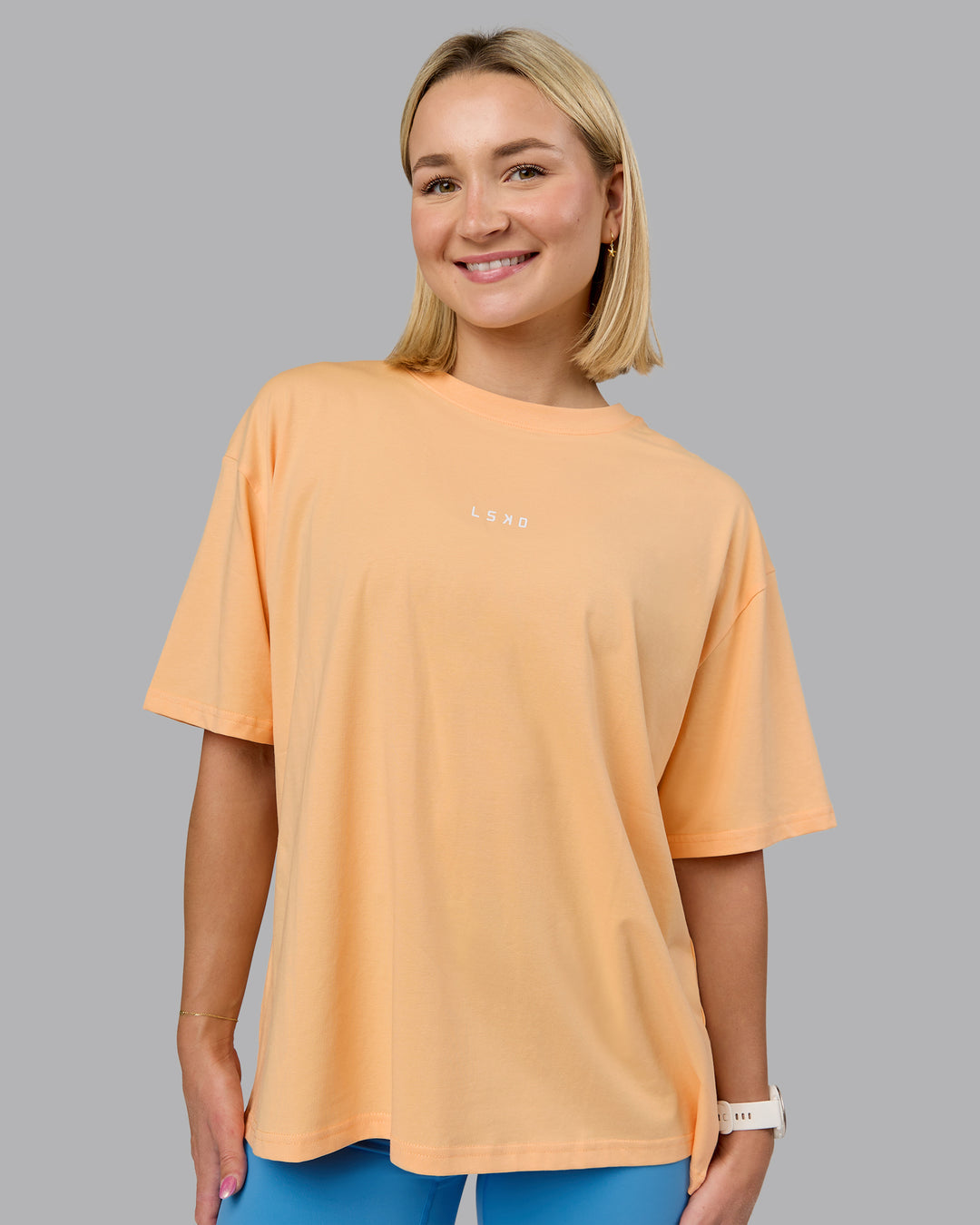 Woman wearing On Repeat FLXCotton Oversized Tee - Peach Fuzz-Light Cyan | Model:Halle | Size:S