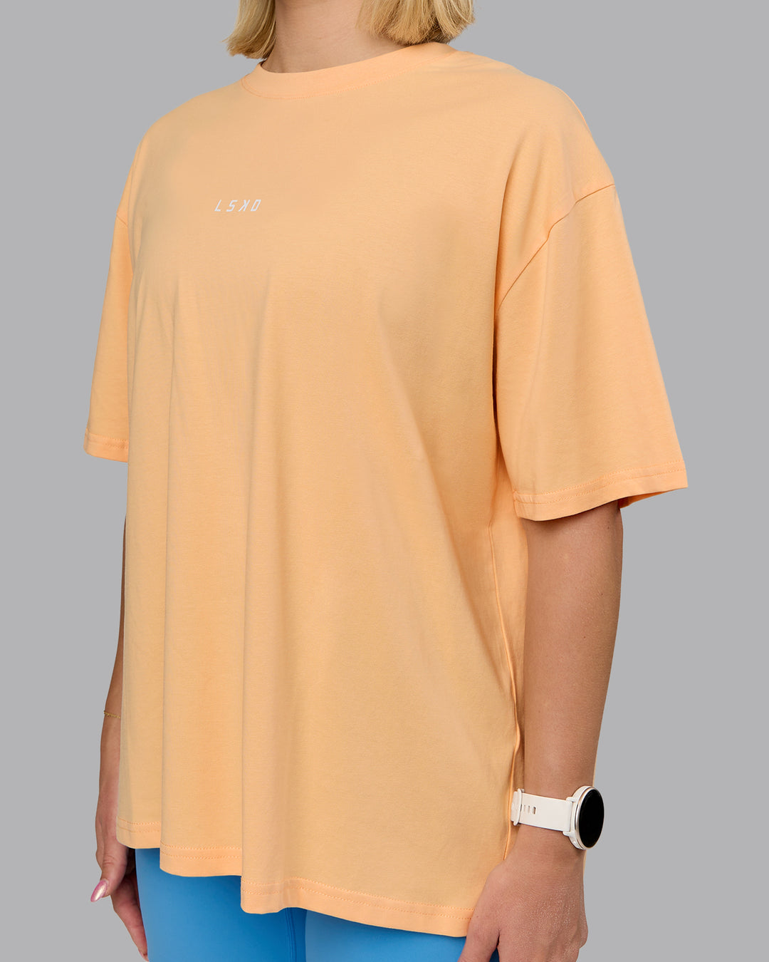 Woman wearing On Repeat FLXCotton Oversized Tee - Peach Fuzz-Light Cyan | Model:Halle | Size:S