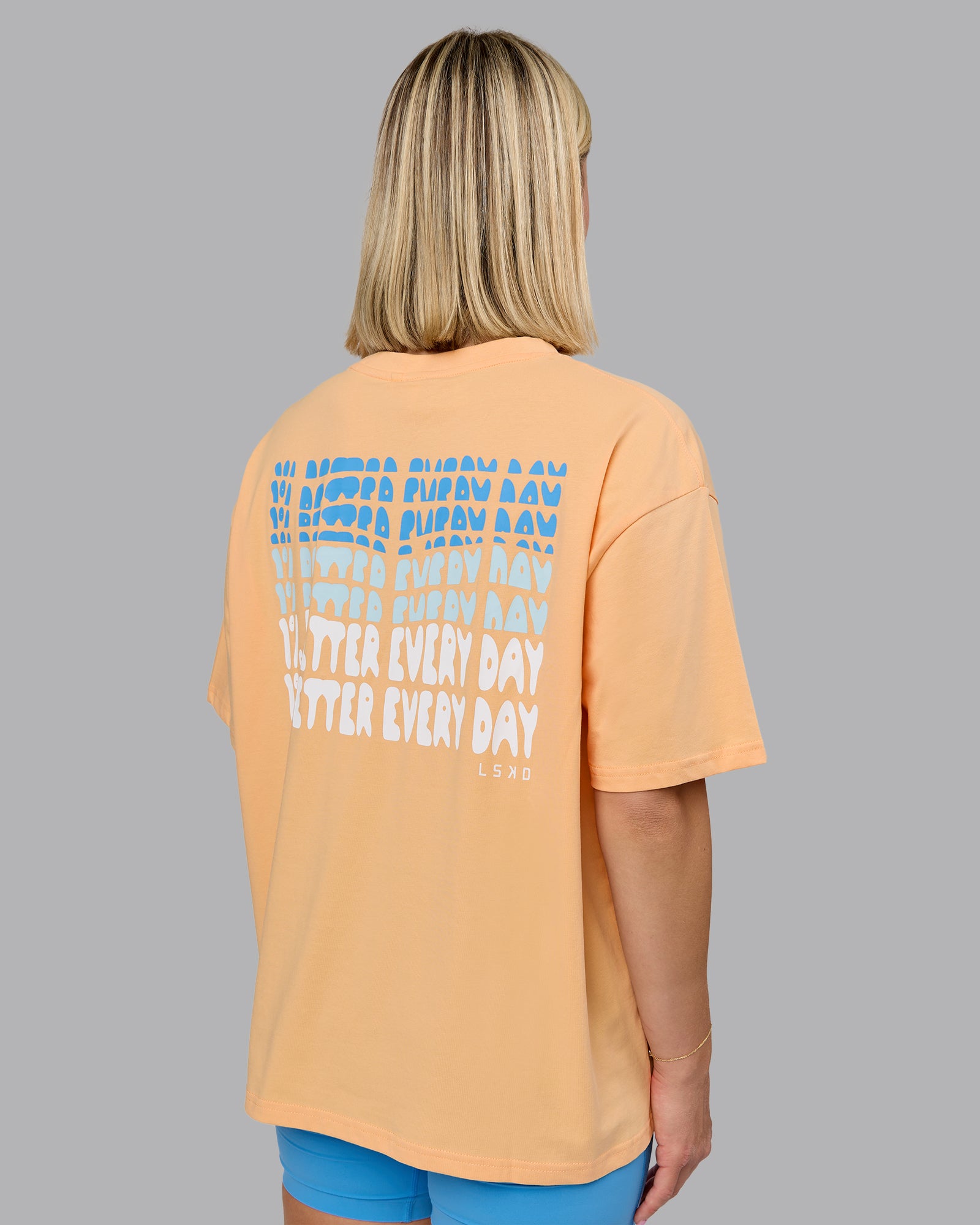 Woman wearing On Repeat FLXCotton Oversized Tee - Peach Fuzz-Light Cyan | Model:Halle | Size:S
