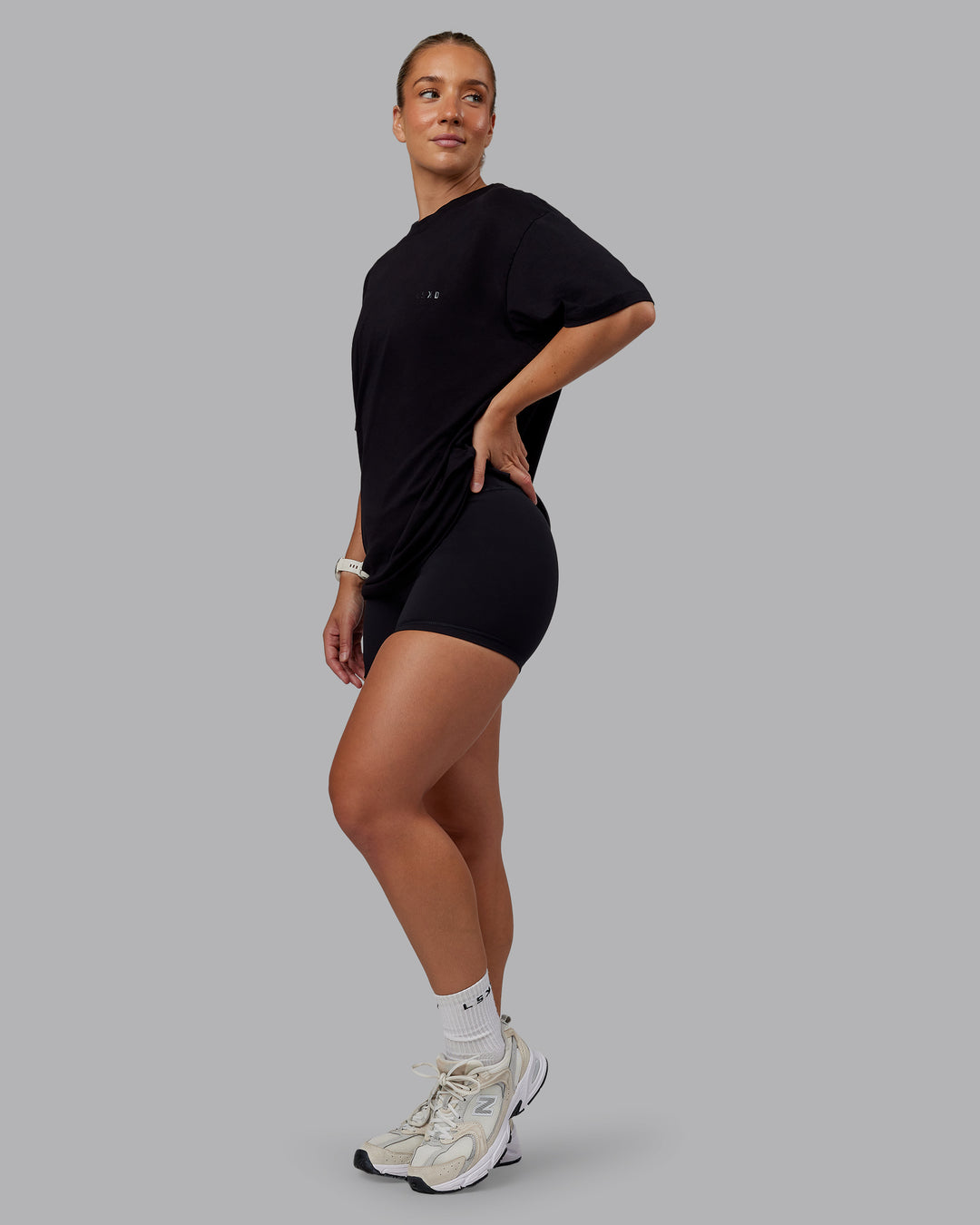 Woman wearing Unisex PimaFLX Tee Oversize - Black | Model:Lyss | Size:XS