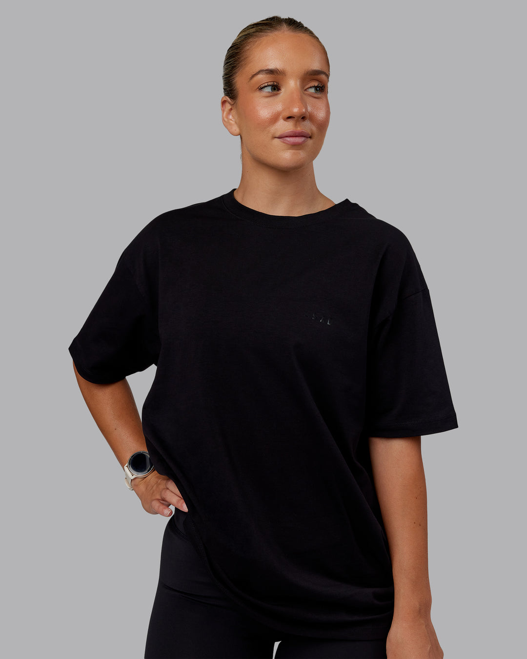 Woman wearing Unisex PimaFLX Tee Oversize - Black | Model:Lyss | Size:XS