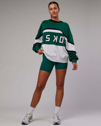 Woman wearing Unisex PrimeTime Sweater Oversize - Malachite-White