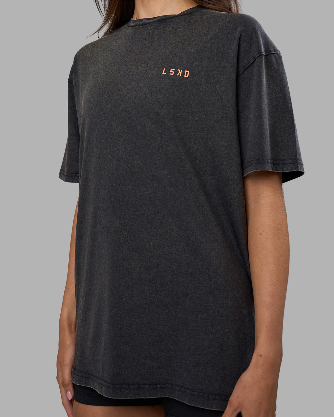 Woman wearing Unisex Strike Through FLXCotton Tee Oversize - Black Washed-Cantaloupe | Model:Phoebe | Size:XS