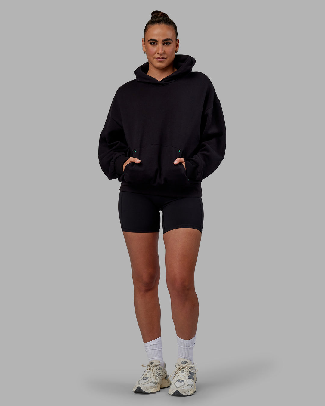 Woman wearing Unisex We Rise Hoodie Oversize - Black-Impact Green