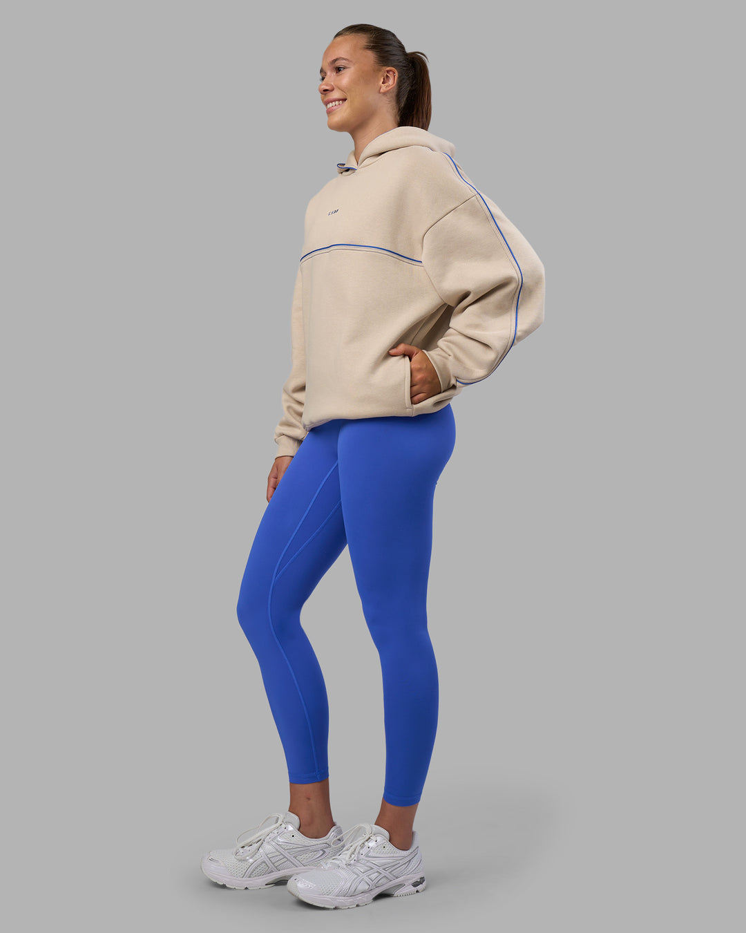 Woman wearing Unisex Oversized Piping Hoodie - Shale Beige-Power Cobalt | Model:Charlize | Size:XS