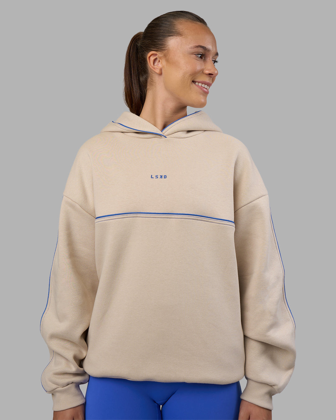 Woman wearing Unisex Oversized Piping Hoodie - Shale Beige-Power Cobalt | Model:Charlize | Size:XS