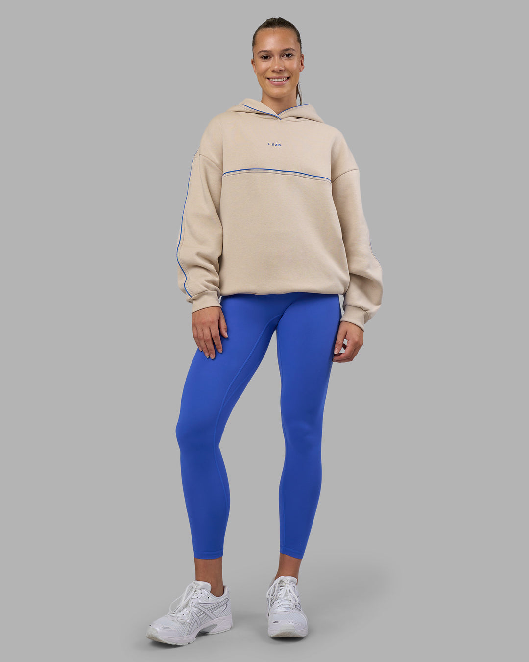 Woman wearing Unisex Oversized Piping Hoodie - Shale Beige-Power Cobalt | Model:Charlize | Size:XS