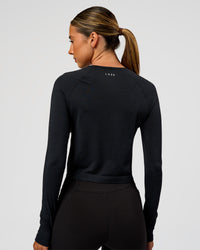 Woman wearing AeroFLX+ Seamless Long Sleeve Skimmer Tee - Black Marl | Model:Charli | Size:XS