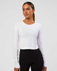 Woman wearing AeroFLX+ Seamless Long Sleeve Skimmer Tee - White/White | Model:Charli | Size:XS