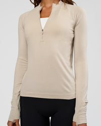 Woman wearing AeroFLX+ Long Sleeve Half Zip - Shale Beige/Shale Beige | Model:Dakota | Size:XS