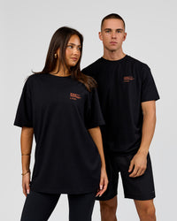 Duo wearing Coffee Run FLXCotton Oversized Tee - Black-Ultra Orange | Model:Albert | Size:M | Model:Bianca | Size:XS | Thumbnail Index: 1