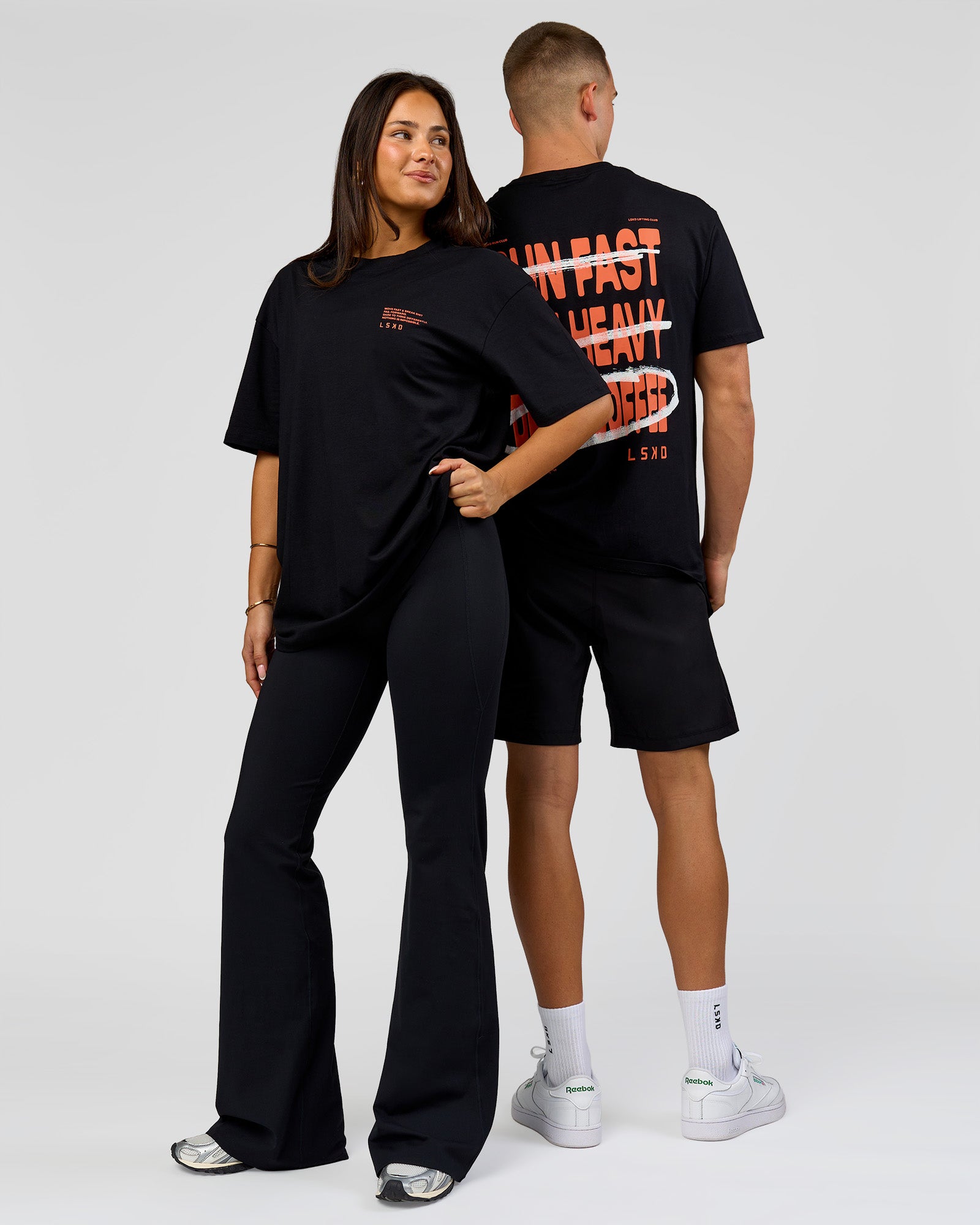 Duo wearing Coffee Run FLXCotton Oversized Tee - Black-Ultra Orange | Model:Albert | Size:M | Model:Bianca | Size:XS