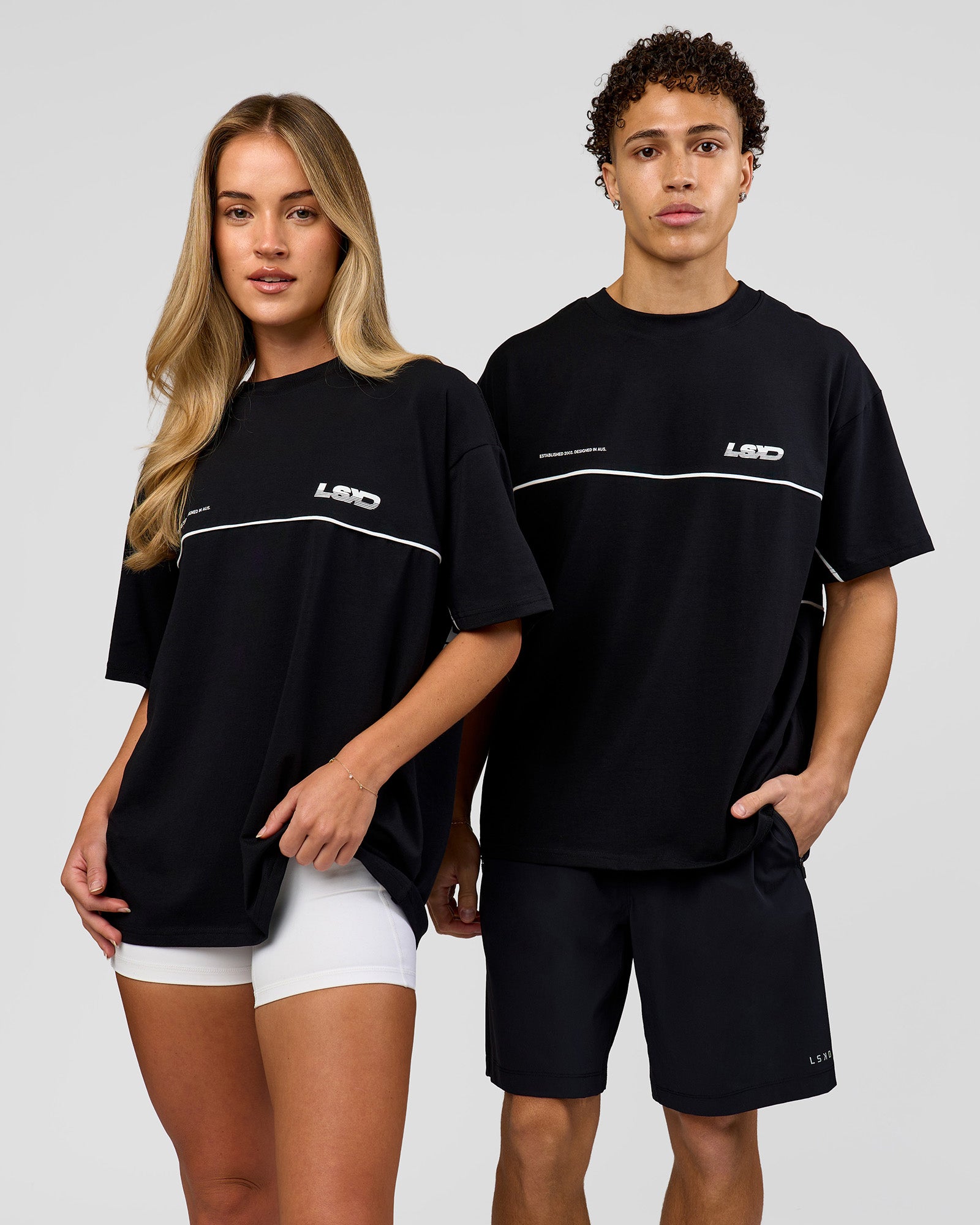 Duo wearing Inline Heavyweight FLXCotton Oversized Tee - Black-White | Model:Issy | Size:XS | Model:Leandro | Size:M