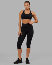 Woman wearing O.G. Fusion Ultra High-Rise 3/4 Legging Pockets - Black | Model:Milly | Size:S