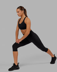 Woman wearing O.G. Fusion Ultra High-Rise 3/4 Legging Pockets - Black | Model:Milly | Size:S