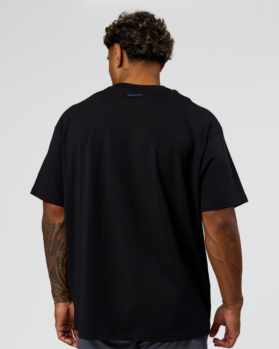 Man wearing League Heavyweight FLXCotton Oversized Tee - Black-Power Cobalt | Model:Xav | Size:L