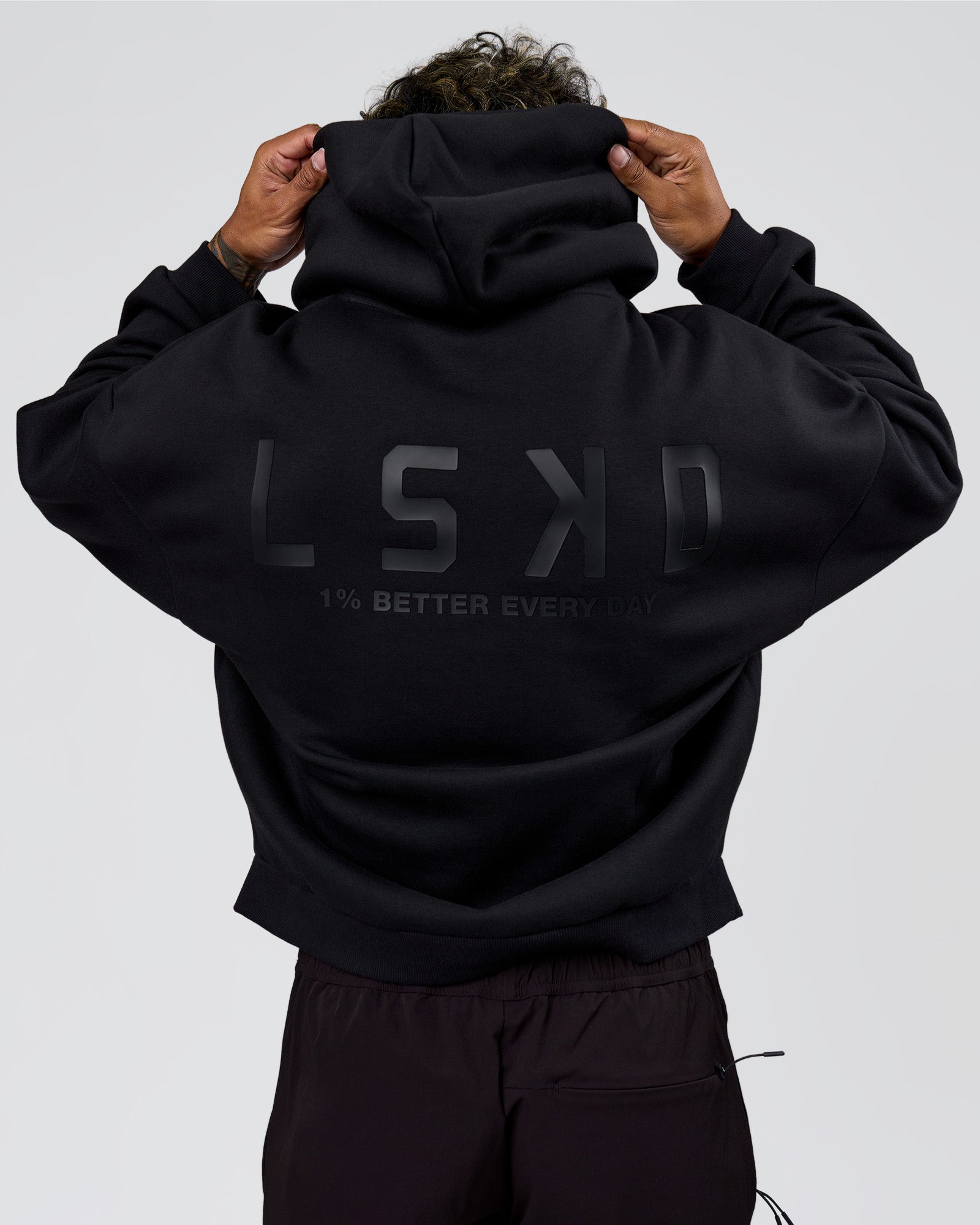 Man wearing Tonal Legacy Boxy Hoodie - Black-Black | Model:Xav | Size:L