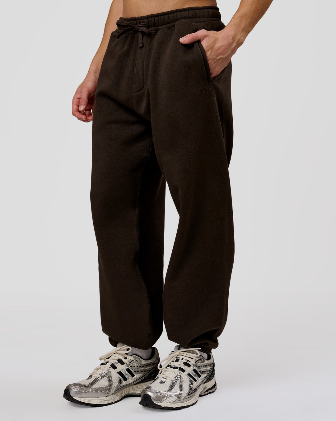 Man wearing Base Baggy Cuffed Track Pant - Ground Coffee | Model:Leandro | Size:M - view 1