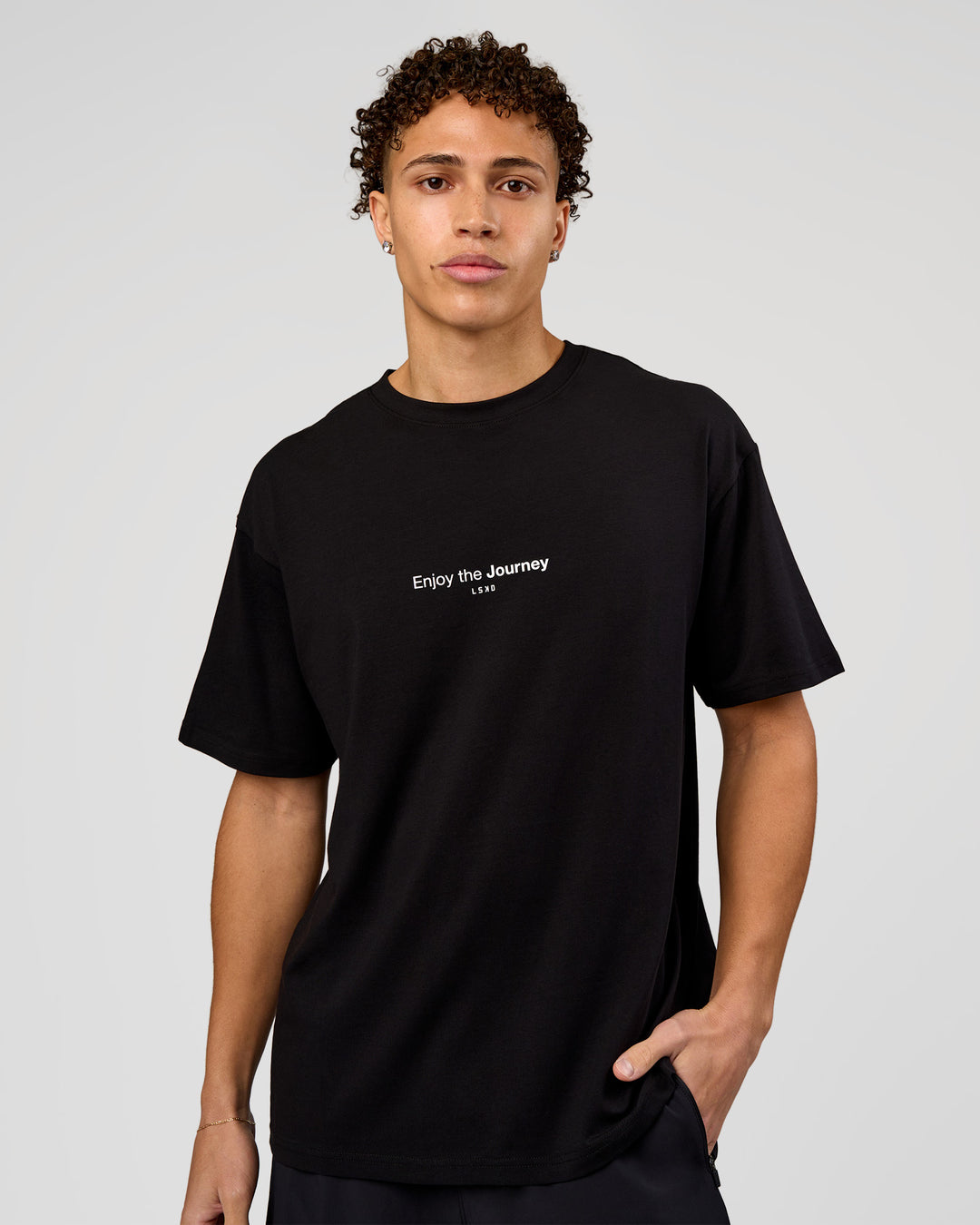 Man wearing VS1 Enjoy The Journey FLXCotton Oversize Tee - Black | Model:Leandro | Size:M - view 2