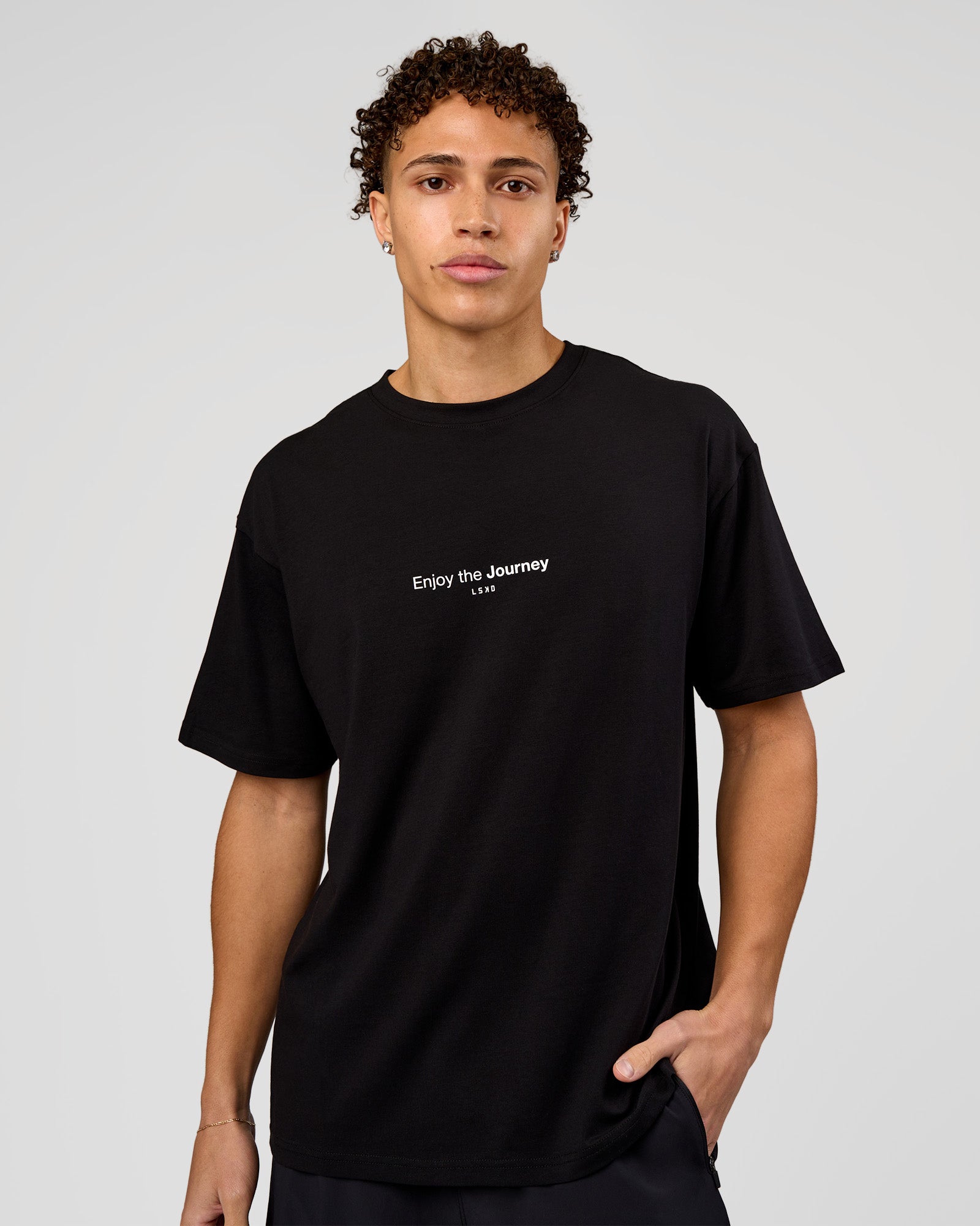 Man wearing VS1 Enjoy The Journey FLXCotton Oversize Tee - Black | Model:Leandro | Size:M