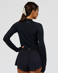 Woman wearing AeroFLX+ Long Sleeve Skimmer Half Zip - Black Marl | Model:Bianca | Size:S