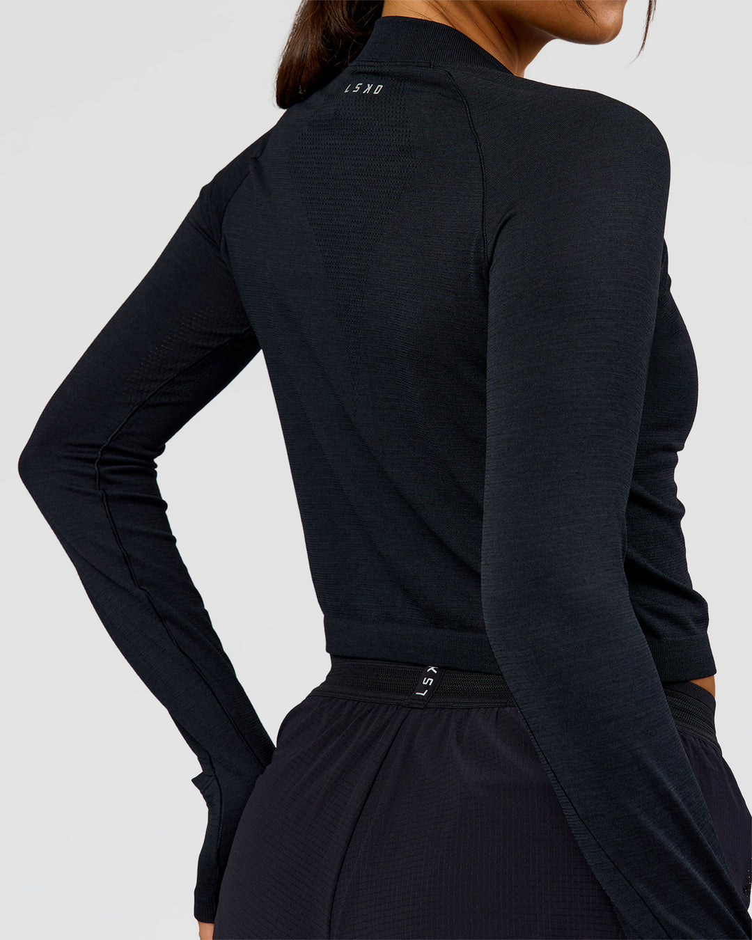 Woman wearing AeroFLX+ Long Sleeve Skimmer Half Zip - Black Marl | Model:Bianca | Size:S