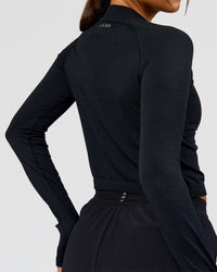Woman wearing AeroFLX+ Long Sleeve Skimmer Half Zip - Black Marl | Model:Bianca | Size:S