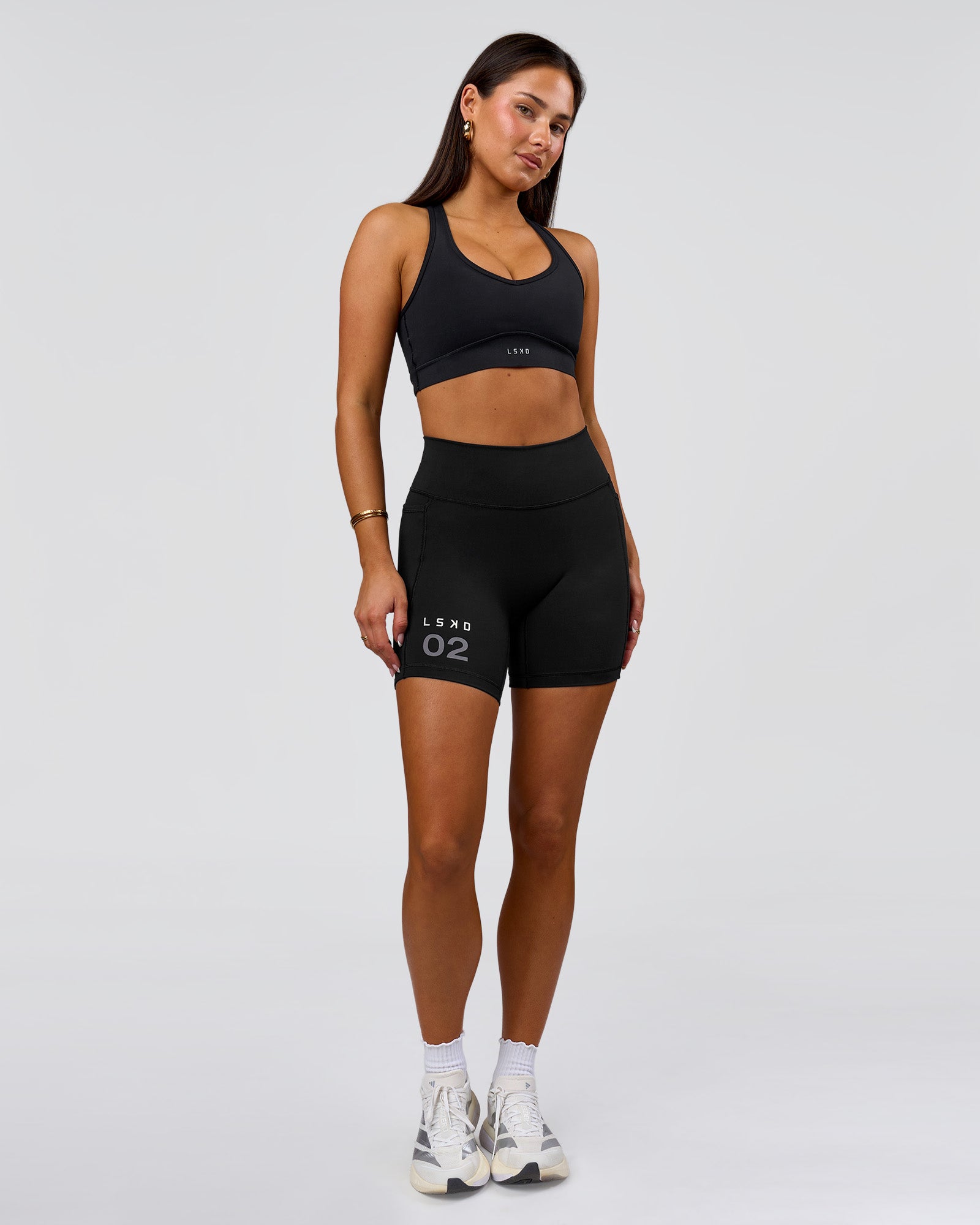 Woman wearing Fusion V-Contour High-Rise 6" Short Pockets - Black-Tech Department | Model:Bianca | Size:S