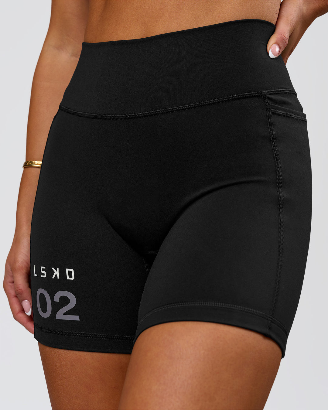 Woman wearing Fusion V-Contour High-Rise 6" Short Pockets - Black-Tech Department | Model:Bianca | Size:S - view 1
