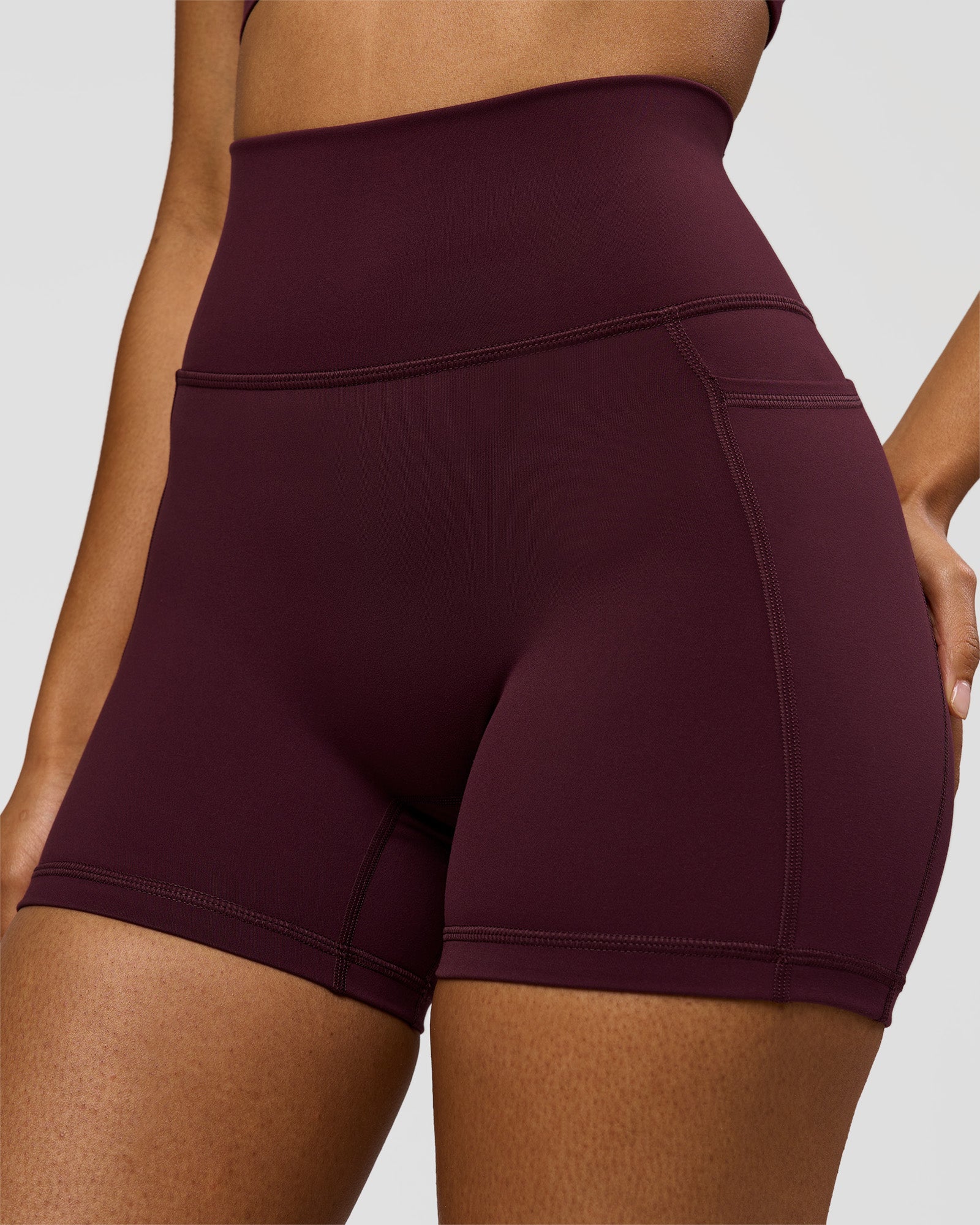Woman wearing Fusion Ultra High-Rise 4" Short Pockets - Cherry Lacquer | Model:Jordan | Size:S