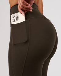Woman wearing Fusion V-Contour High-Rise Flared Legging Pockets - Ground Coffee | Model:Jordan | Size:S | Thumbnail Index: 2