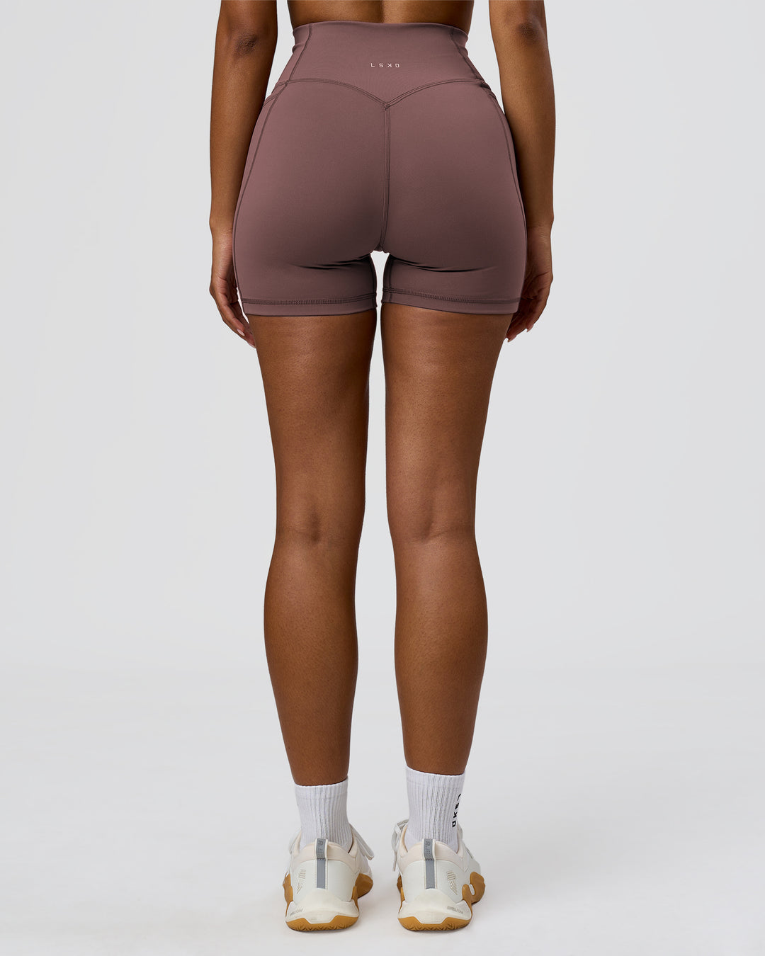 Woman wearing Fusion V-Contour Ultra High-Rise 4" Short Pockets - Cocoa Powder | Model:Jordan | Size:S - view 4