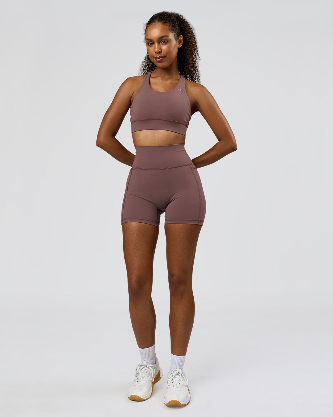 Woman wearing Fusion V-Contour Ultra High-Rise 4" Short Pockets - Cocoa Powder | Model:Jordan | Size:S - view 8