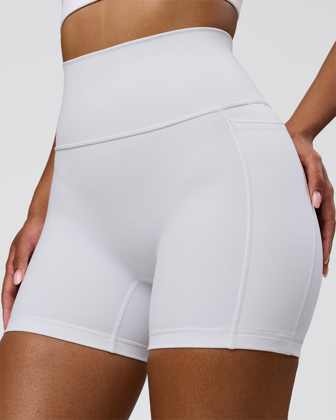 Woman wearing Fusion V-Contour Ultra High-Rise 4" Short Pockets - White | Model:Jordan | Size:S - view 3