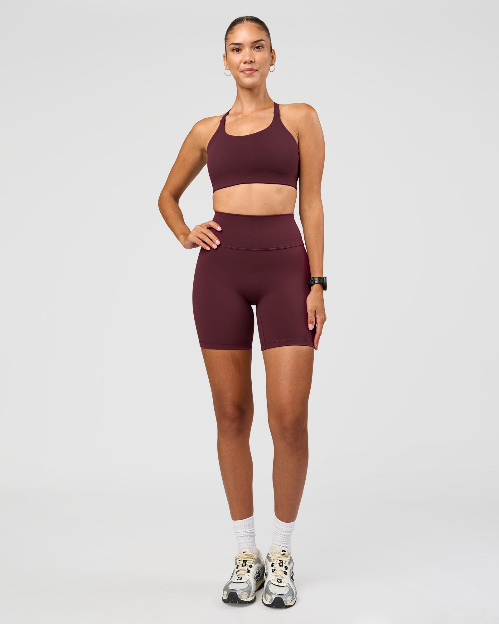 Woman wearing Twist Sports Bra D/DD/E - Cherry Lacquer | Model:Rhiley | Size:S
