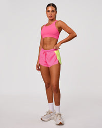 Woman wearing Accelerate 3" Mid-Rise Running Short - Lime Glo-Sugar Plum | Model:Charli | Size:XS | Thumbnail Index: 6