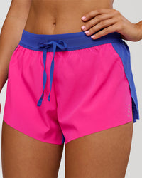 Woman wearing Accelerate 3" Mid-Rise Running Short - Power Cobalt- Ultra Pink | Model:Charli | Size:XS | Thumbnail Index: 0