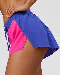 Woman wearing Accelerate 3" Mid-Rise Running Short - Power Cobalt- Ultra Pink | Model:Charli | Size:XS | Thumbnail Index: 1