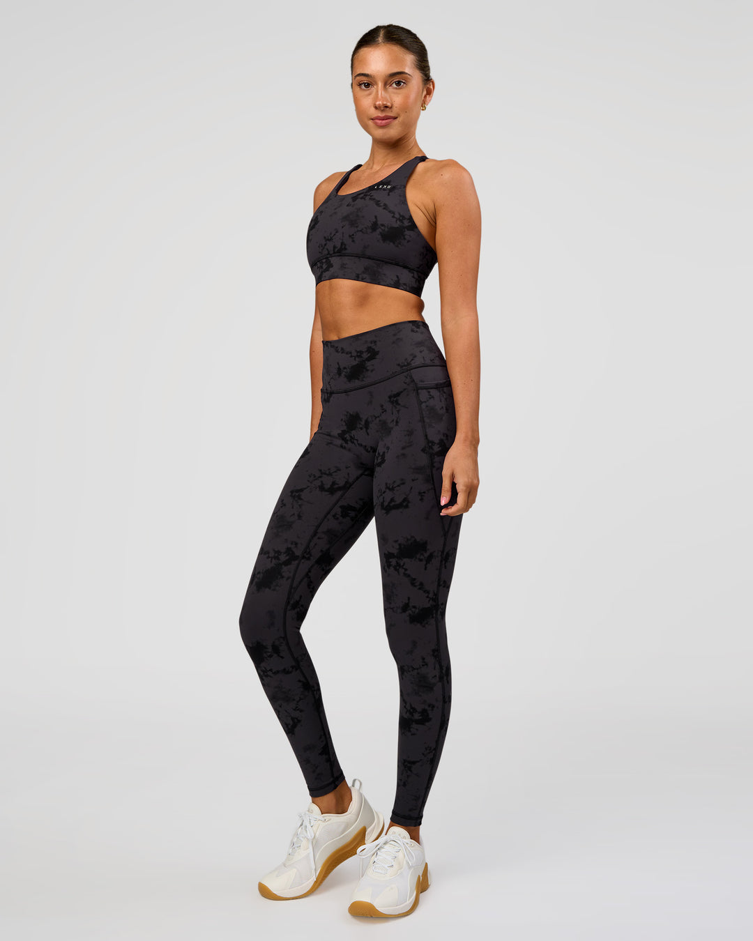 Woman wearing Accelerate Split Strap Sports Bra - Black Tie Dye | Model:Charli | Size:XS - view 3