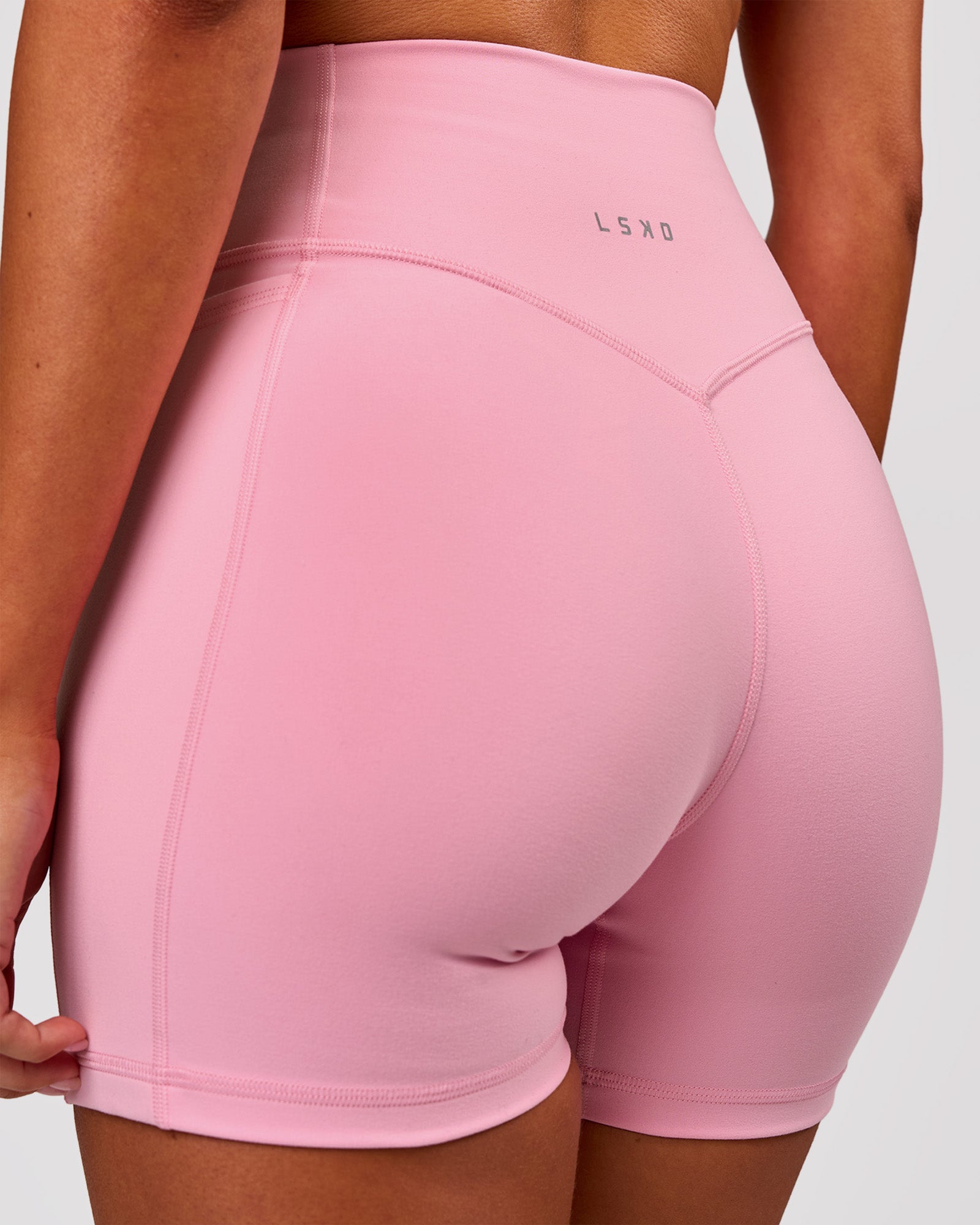 Woman wearing Fusion V-Contour Ultra High-Rise 4" Short Pockets - Pink Rose | Model:Charli | Size:XS