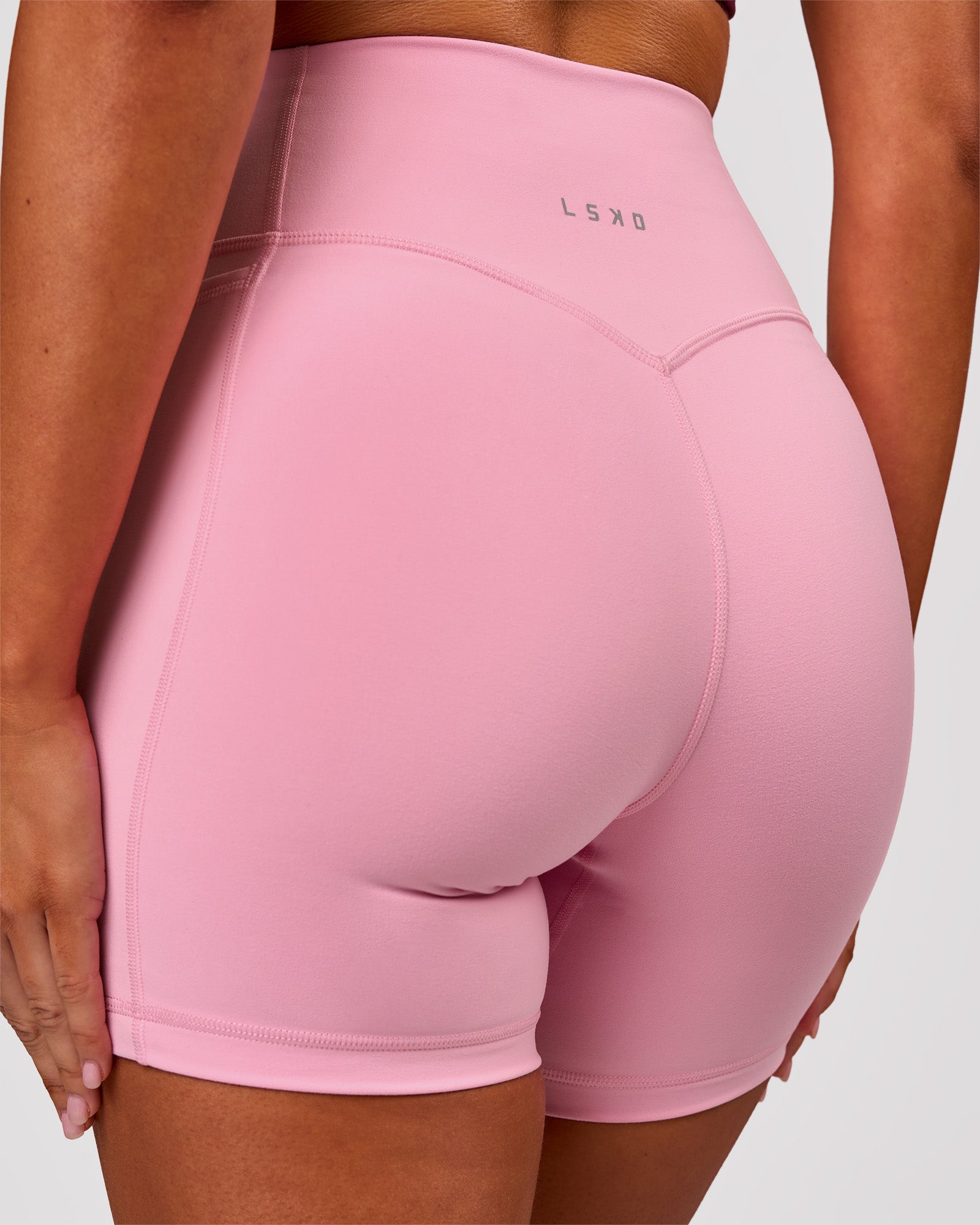 Woman wearing Fusion V-Contour Ultra High-Rise 6" Short Pockets - Pink Rose | Model:Charli | Size:XS